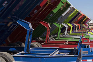 Underside of dump trailers lined up in different colors