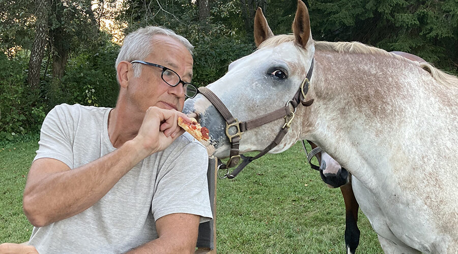 Buck feeding Brody a slice of pizza