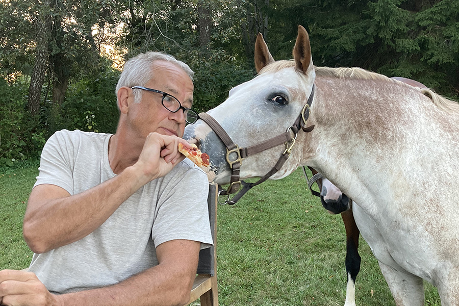 Buck feeding Brody a slice of pizza