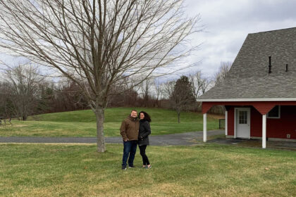 Alicia and husband in front of barn door