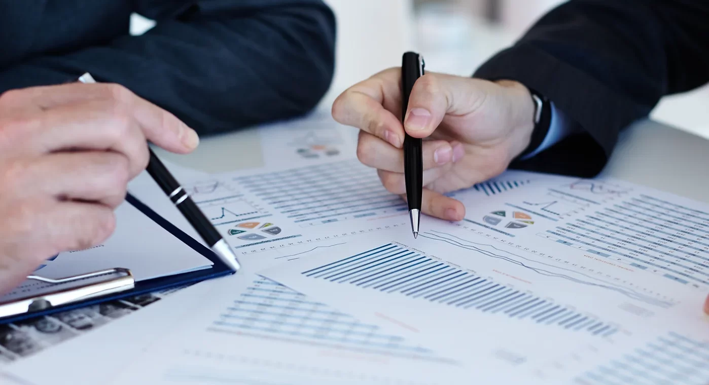 Papers with hands holding pens