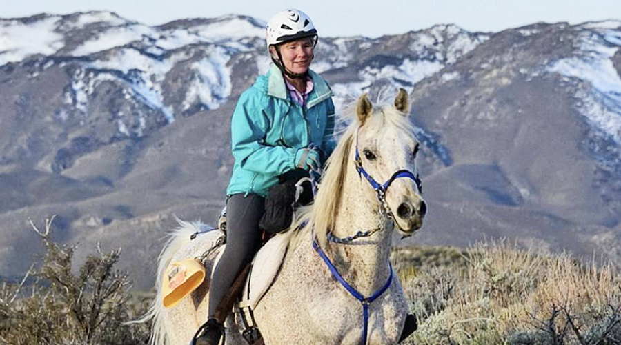 Karen riding her grey Arabian horse, Chief